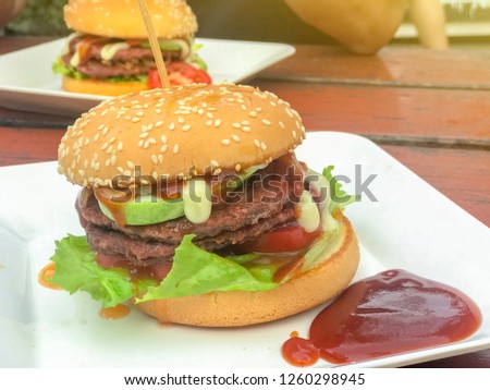 close up of homemade hamburgers with ketchup on white plate