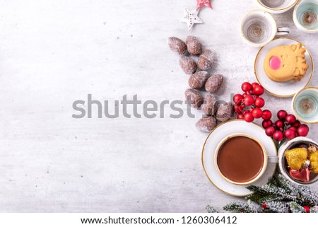 Home made hot chocolate decorated with deer shaped cookies and pine shaped chocolate candies and traditional Christmas decoration. Top View. Copy space