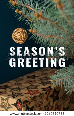 Winter holidays concept. Close up of craft Christmas gifts under the christmas tree. Season's Greeting text