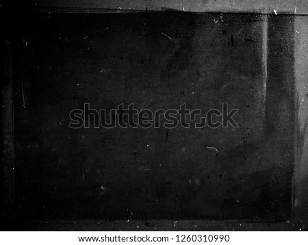 Black grunge scratched scary background with frame, distressed chalkboard, old film effect, copy space Royalty-Free Stock Photo #1260310990