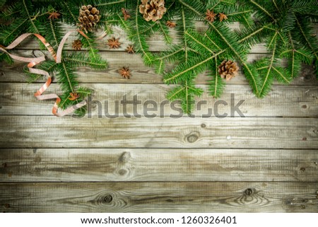 Christmas decoration and tree branches on old deck wooden background
