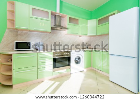 The photo of completely equipped light kitchen with household appliances