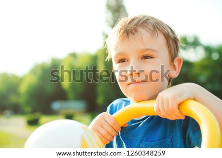 Portrait of happy cute child. Joyful little boy having fun outdoors. Summer vacation concept. Beautiful kid on nature background, close up. Happy and healthy childhood. Little child dreaming