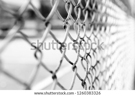 Rusty steel wire mesh fence. Selective focus and blurred background. Black and White picture.