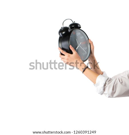 Female hands holding big alarm clock isolated on white