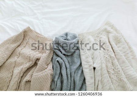 Flat lay autumn and winter fashion photography. Stylish women outfit. Brown knitted sweaters and gray turtleneck. Trendy comfy clothes