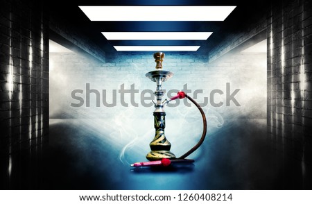 Hookah smoking on the background of a  wall, concrete floor, in clouds of smoke and neon light