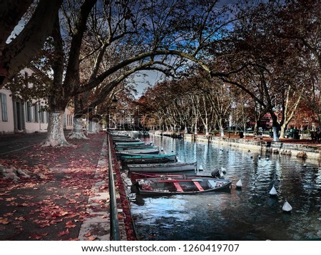 Shot of the beautiful Canal du Vassè which brings to the romantic Pont de Amours in Annecy, France. The canal is full of boats. The shot is taken in autumnal season