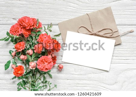 Stylish branding mockup to display your artworks. greeting card and rose flowers in Living Coral color. Pantone color of the year 2019. Flat lay top view