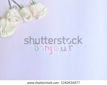 Bonjour ( good morning ) flat lay on a pink purple background with roses