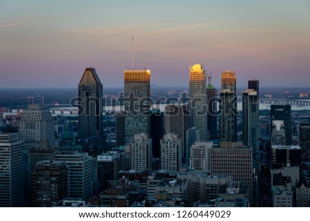 Montreal at sunset with the sun touching the last highest floors of the skyscrapers, view from Kondiaronk Belvedere, Quebec, Canada
