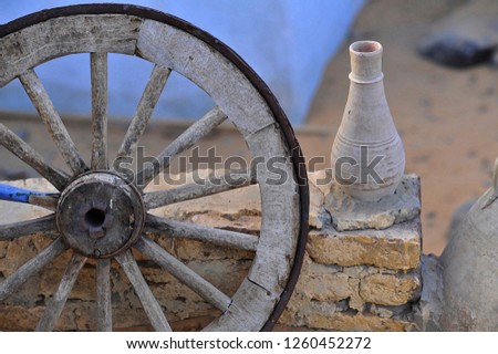 Realistic old wooden wheel and jug clay
