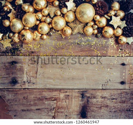 Christmas wooden background with pinecone and golden balls. New year concept. Top view with copy space.