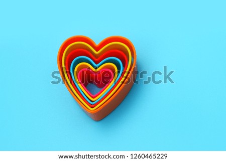 Colored different plastic heart shape on blue background
