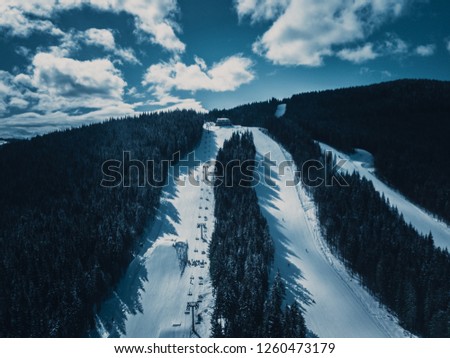 Beautiful aerial drone landscape photo of mountains in cold snowy day.Travel destination for active tourism in winter.Beauty of nature in Carpathian mountain park.Green pine trees grow on hills