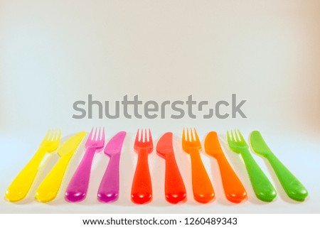 yello pink red orange green forks and knifes isolated