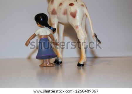 plastic doll of shoulders together with a toy animal