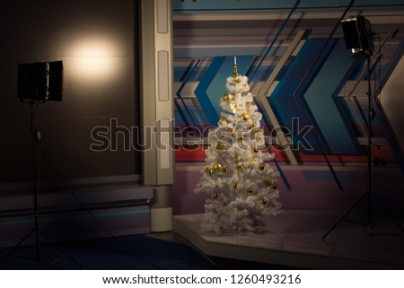 Christmas tree in the Studio video, lighting on both sides. White Christmas tree with gold toys. Christmas office decoration.