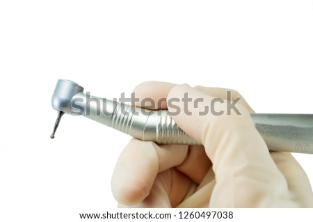 dental handpiece in the hands of the dentist isolated on white background close-up, dental drill, burr Royalty-Free Stock Photo #1260497038