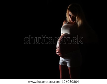 Silhouette of a pregnant woman on a black background