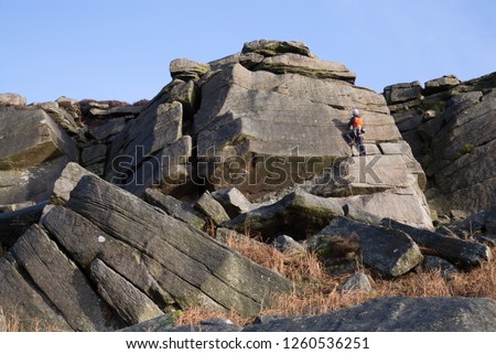 Climbers tackle a challenging boulder face at Burbage Edge, popular for climbing and bouldering, Peak District, England, UK Royalty-Free Stock Photo #1260536251
