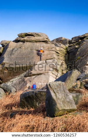 Climbers tackle a boulder face at Burbage Edge, Peak District, England, UK Royalty-Free Stock Photo #1260536257