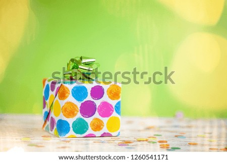 Colorful gift box on lime color background. Holiday greeting card.