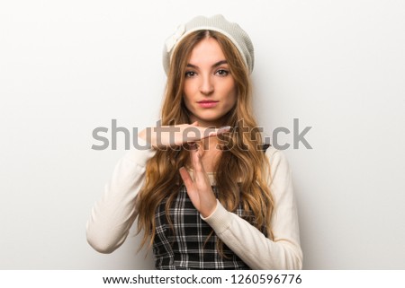 Fashionably woman wearing hat making stop gesture with her hand to stop an act