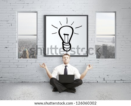 businessman meditating in loft, idea concept