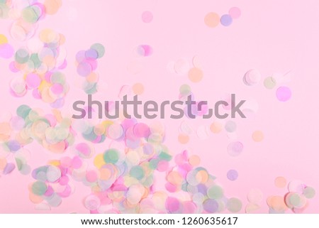 Vibrant confetti on pastel pink background. Festive backdrop for your design.