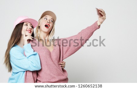Two teenage girls friends in hipster outfit make selfie