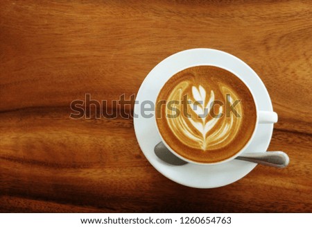 A cup of cappuccino with latte art on wooden background. Beautiful foam, white ceramic cups, , place for text. - Image.