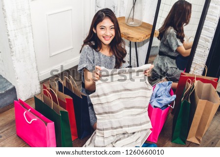 Happy woman shopping and choosing clothes in a store with colorful shopping bag.fashion shopping concept