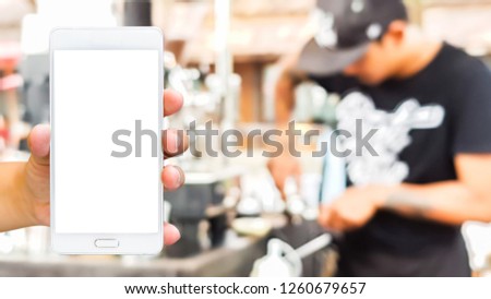 Man use mobile phone, blur image of street coffee as background. (vintage tone)