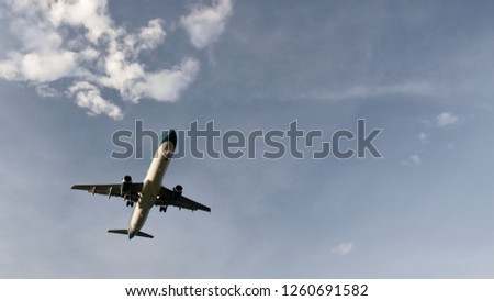 Atmospheric photo of an airplane flying across the blue sky past the clouds . Copy space fot text