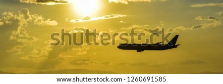 airplane silhouette on the background of a beautiful cloudy sky light yellow