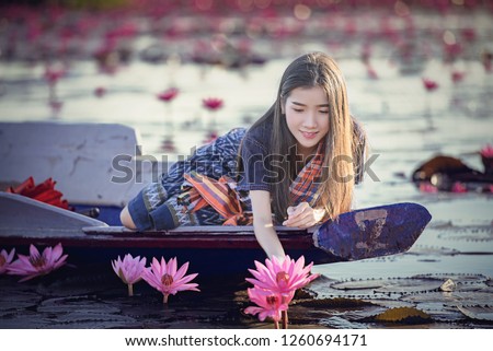 Picture of beautiful Laos woman with lotus flower,young woman relaxing with beautiful lotus flower field at the Red Lotus Sea, Bua Daeng, Udon Thani,Morning Sea of Red Lotus,Unseen nature in Thailand.
