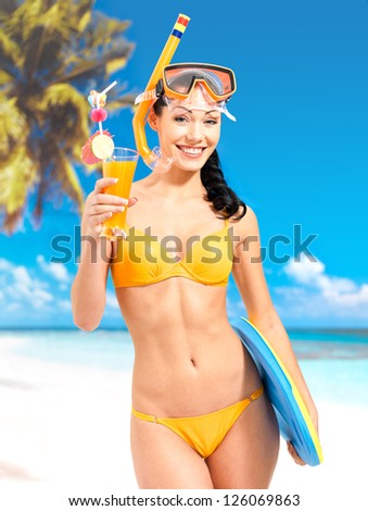 Happy beautiful woman enjoying at beach. Pretty girl with a protective swim mask on the head.