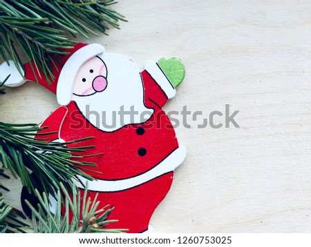 Background for Christmas cards. Christmas green Christmas tree and Santa's toy are located on the left, composing on a light wooden background.
