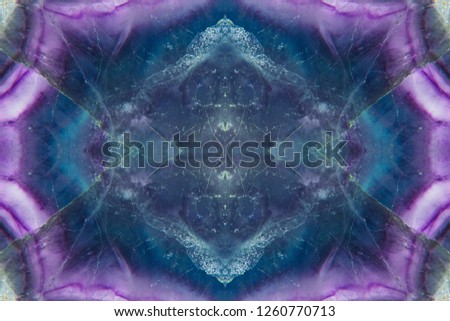 Abstract symmetric pattern of texture of green and purple fluorite mineral stone. Amazing seamless pattern and texture of striped and spotted mineral for background. The image with mirror effect.