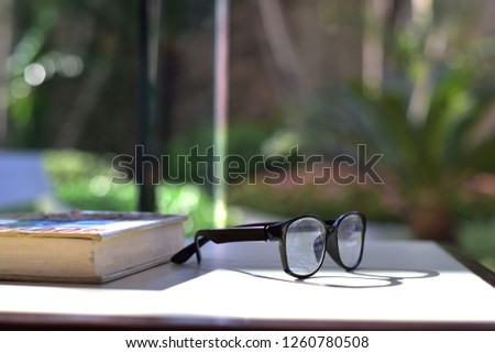 closeup book and glasses on table in library