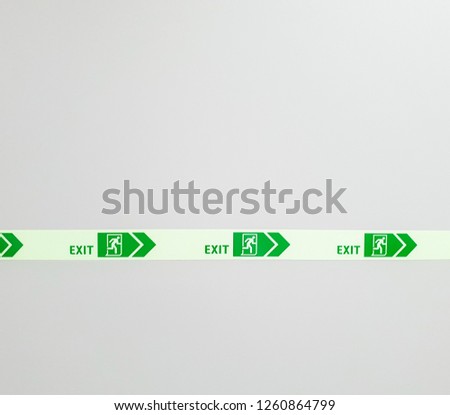 A line of green pictogram tape of emergence exit