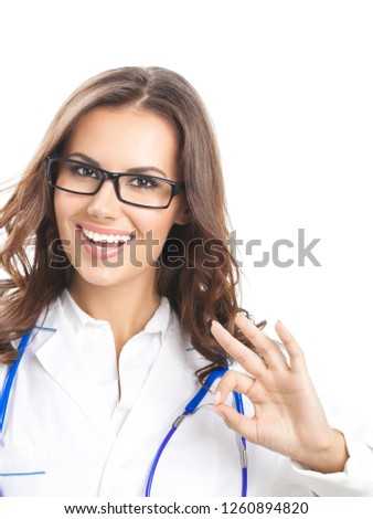 Portrait of happy smiling young female doctor showing okay gesture, isolated over white background