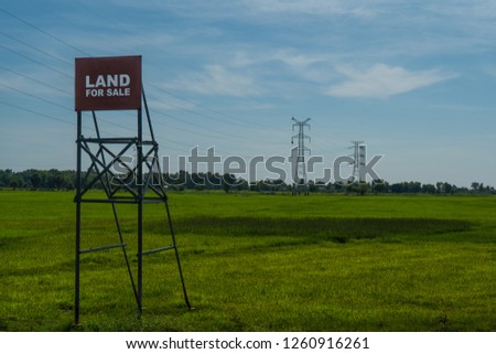 Land for sale sigh on green field  