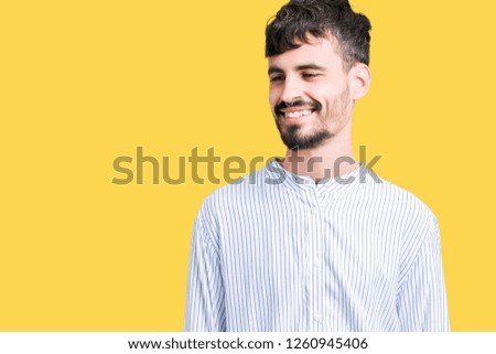 Young handsome business man over isolated background looking away to side with smile on face, natural expression. Laughing confident.