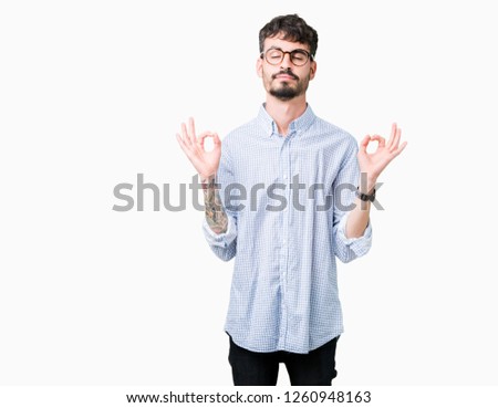 Young handsome man wearing glasses over isolated background relax and smiling with eyes closed doing meditation gesture with fingers. Yoga concept.