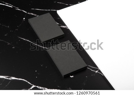 Photo of branding identity mock up on marble. Template isolated on marble background. Black business cards and white letterhead on black marble.