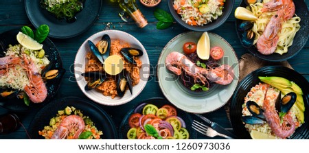 A set of seafood dishes on a blue wooden background. Pasta, bulgur, rice, couscous. Top view. Free space for your text.