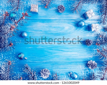 tree branch, ball, snow on a blue wooden background, frame