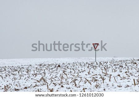 sign give way in a snowy field